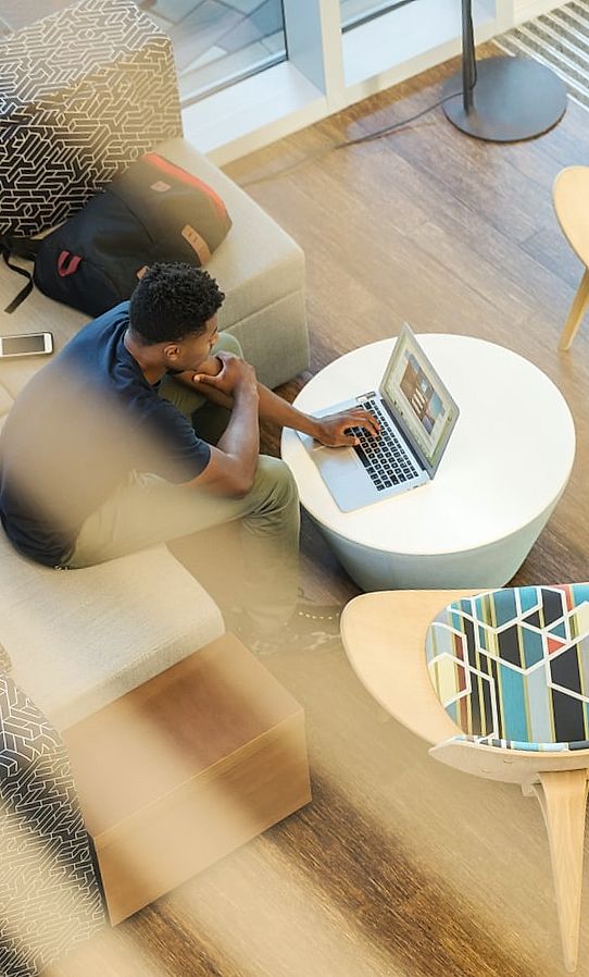 Jonge man zit aan bureau en surfen op internet