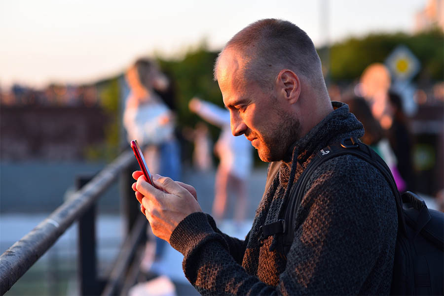 Een man kijkt naar zijn mobiele telefoon